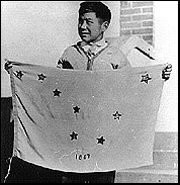 Thirteen-year old Benny Benson holds a handmade flag shortly after winning the flag design contest. Photo: Alaska State Library