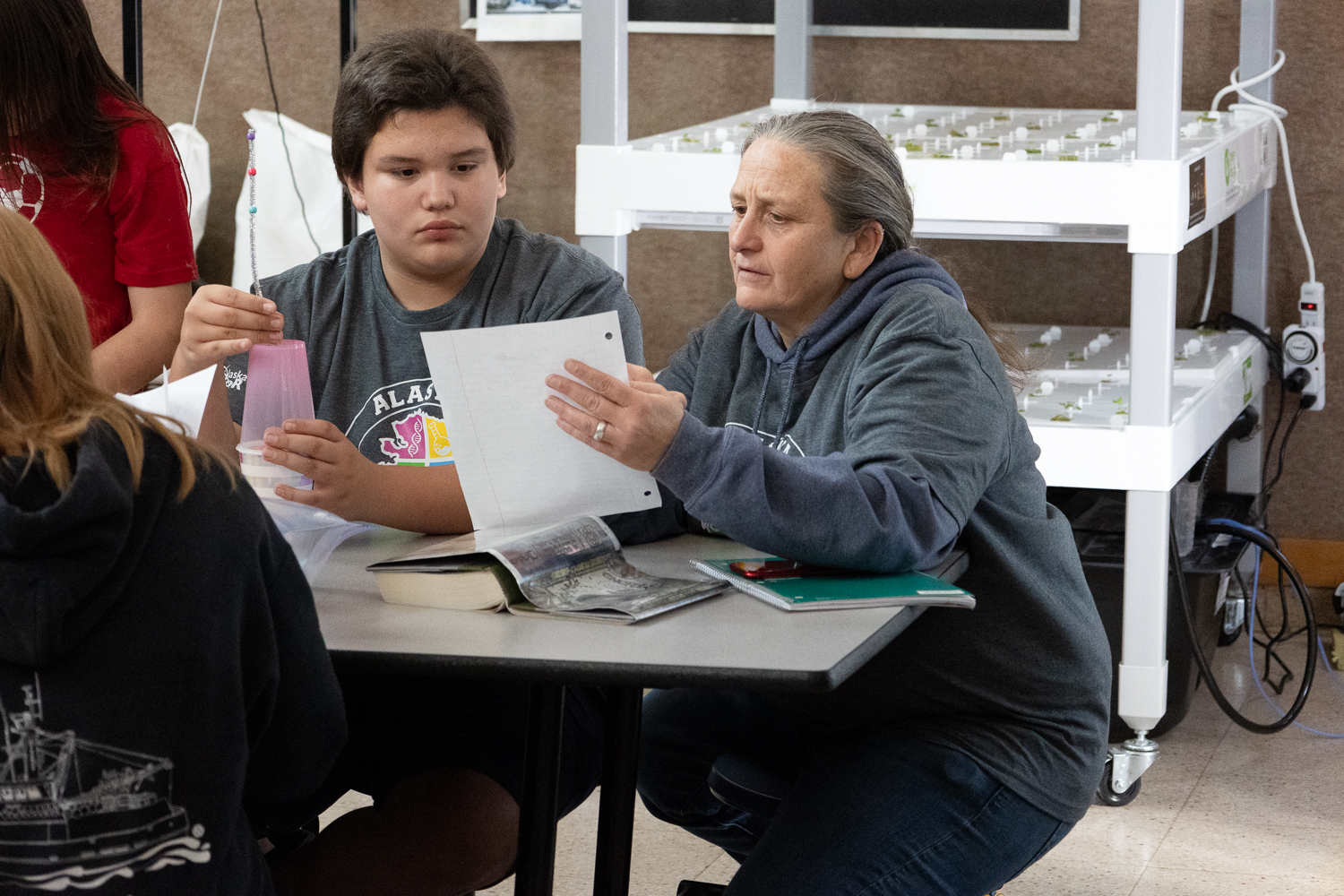 Justina Starzynski-Hotch and a student read the written description for the "Write It, Do It" Science Olympiad challenge. The team must interpret the directions to correctly recreate a design.