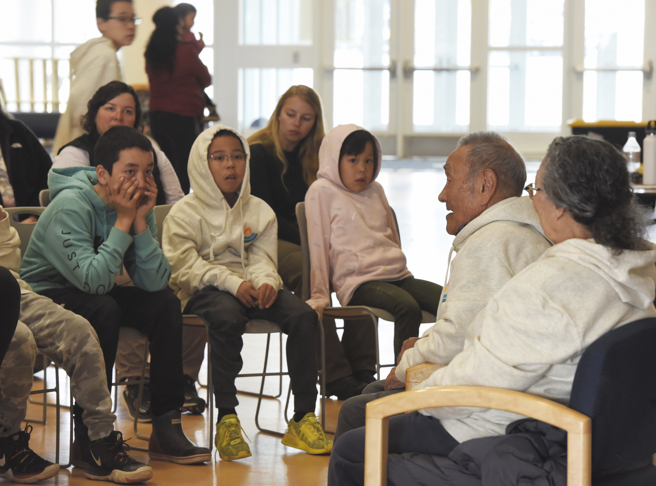Elders speaking with a group of children