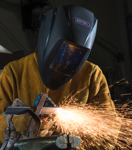 Student welder at Kodiak campus Photo of a student in a helmet welding