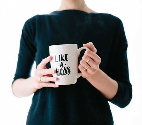 woman holding mug that reads "Like a boss"