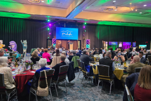 A crowd of people seated at tables celebrate the closing of the For Alaska campaign