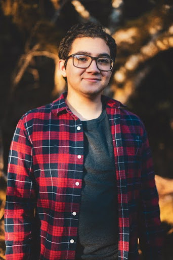 Fernando Escobar young man with dark hair and a red plaid shirt stands