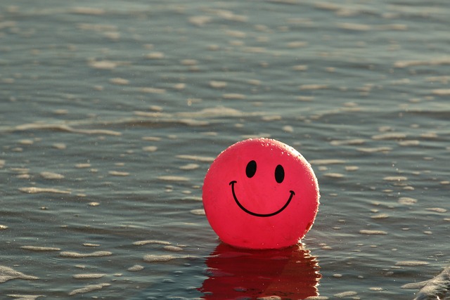 a red ball with a smiley face drawn on it floats in water