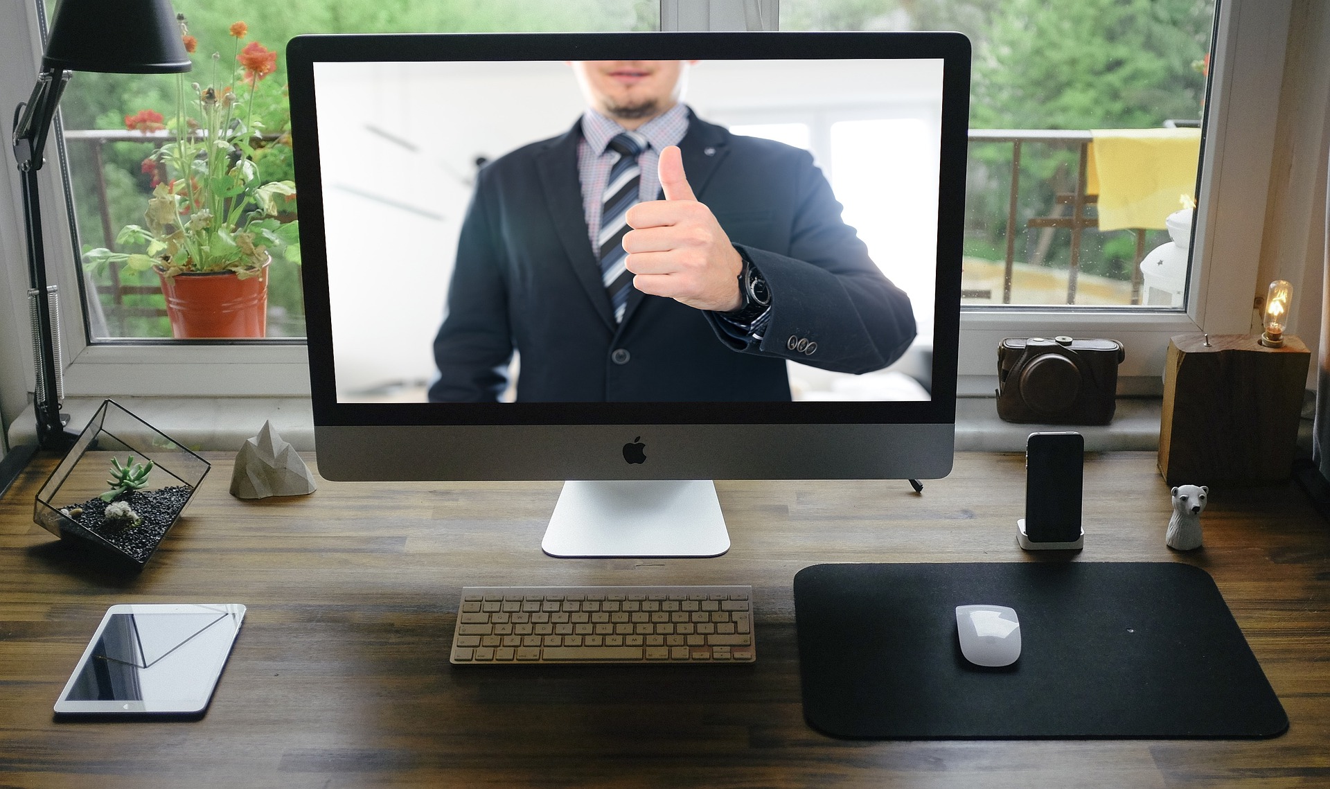 Picture of remote work meeting - person giving a thumbs up via video