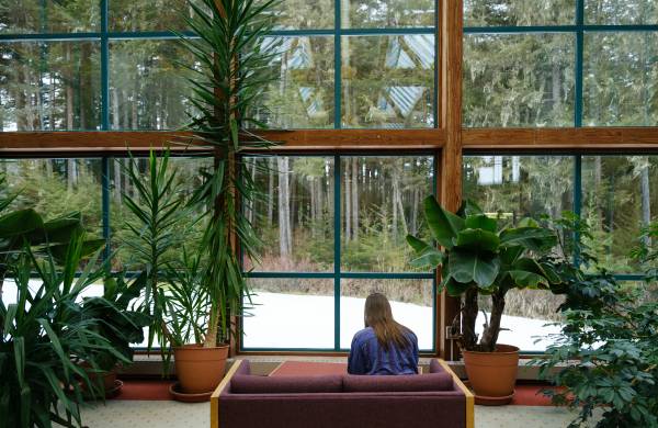 woman sitting on couch, facing the windows