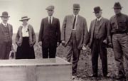 Pictured from left is Judge Wickersham, Harriet Hess, and four other unidentified individuals gathered during the construction of the cornerstone.