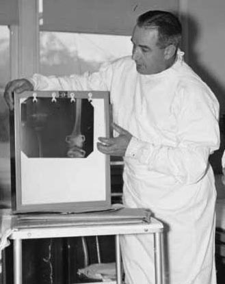 Dr. Philip Moore study an x-ray of patient during "rounds" at Mt. Edgecumbe Medical Center Orthopedic Hospital. Photo: Alaska State Library, Historical Collections